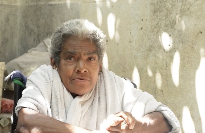 Anai, an elderly woman in Trinidad, Cuba, sitting in her wheelchair outside her home
